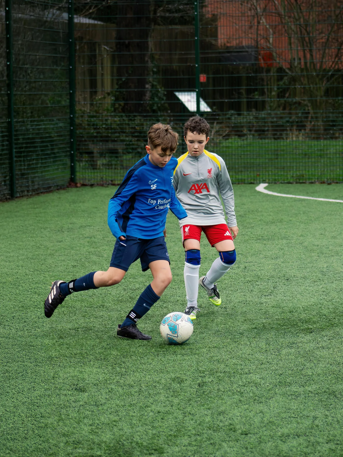 Young player carrying the ball under pressure