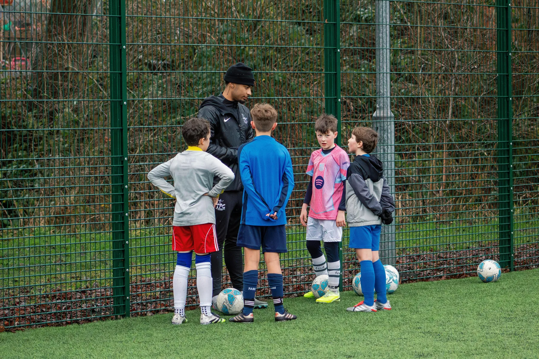 Tyreace speaking to a group of young footballers
