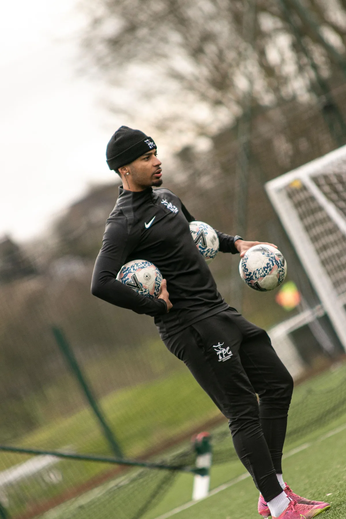 Tyreace Palmer carrying footballs during a coaching session